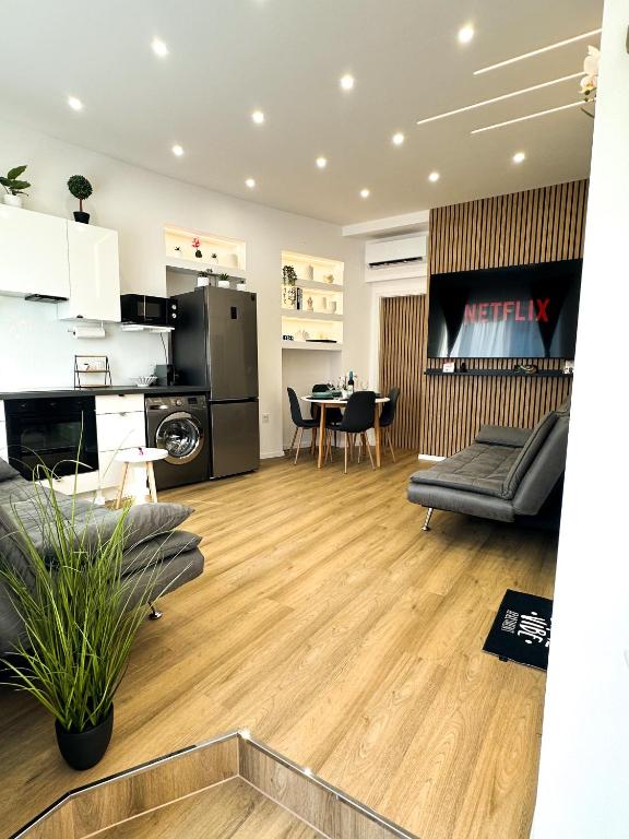 a living room with a kitchen and a dining room at VIBE S33 Apartman Modern & Prémium in Székesfehérvár