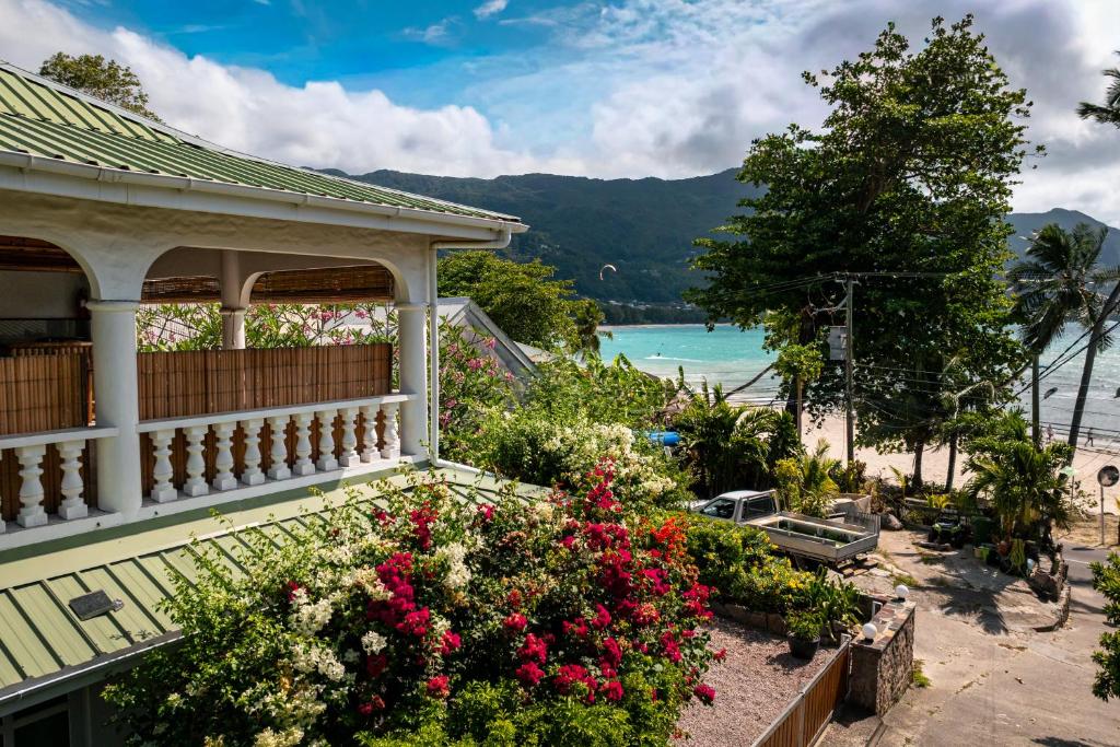 Un balcón de una casa con flores en la playa en Beau Bamboo, en Mahe