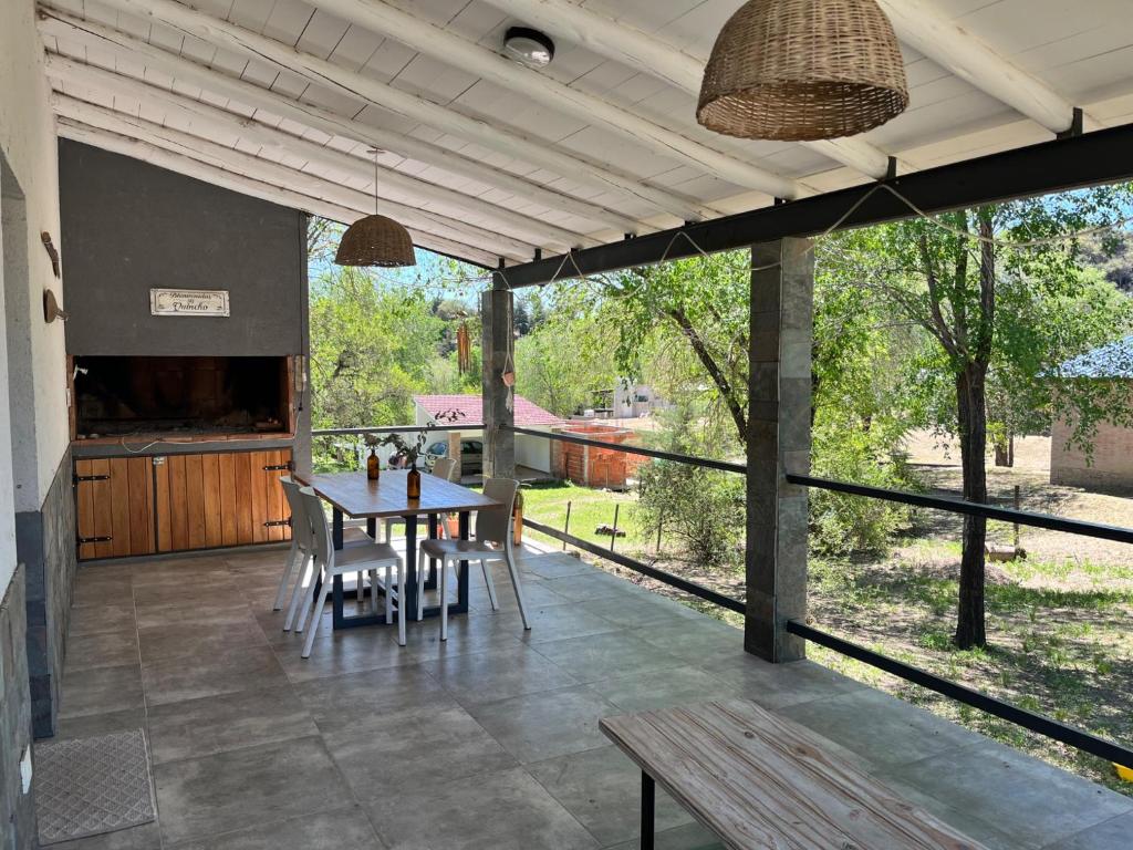 een patio met een tafel en stoelen en uitzicht op een tuin bij La Casa del Gringo in Villa Icho Cruz
