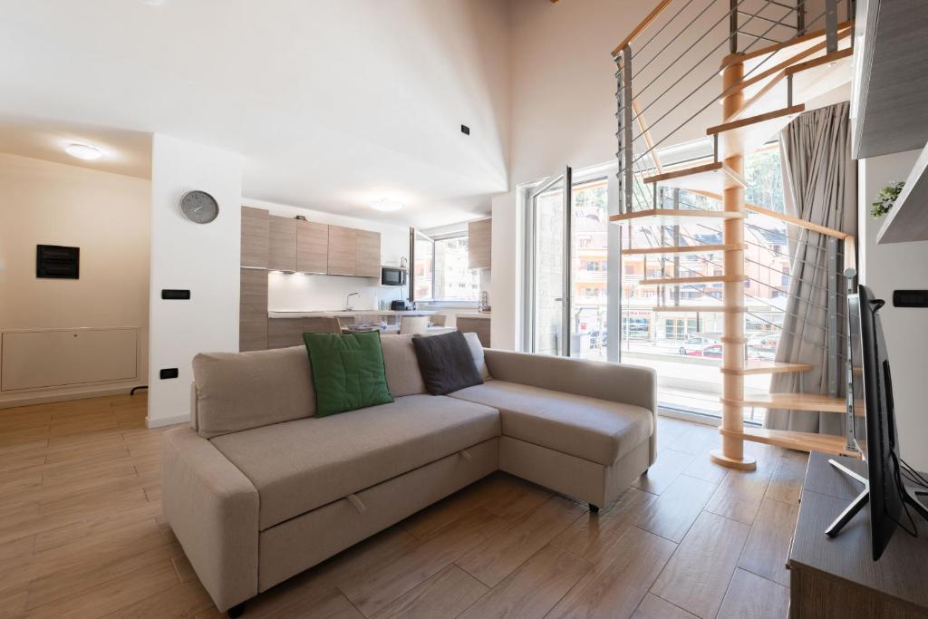 a living room with a couch and a large window at Appartamento Jubilant in Comano