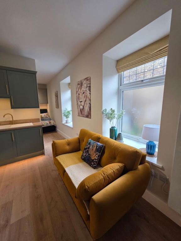 a living room with a couch and a large window at Luxury studio flat, Skipton in Skipton