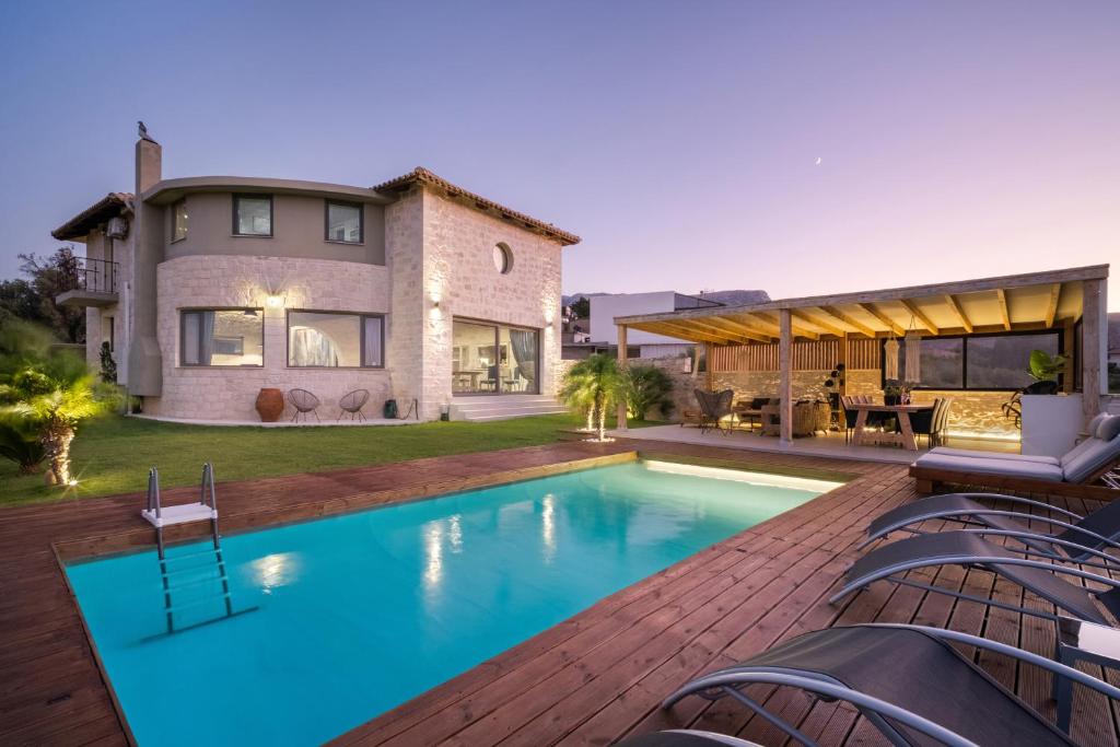 a swimming pool in the backyard of a house at Petra Luxury Villa in Heraklio Town