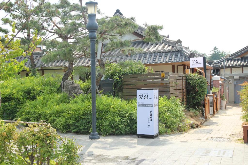 una luz de la calle y un cartel en una acera en Sungsim Hanok Guesthouse, en Jeonju