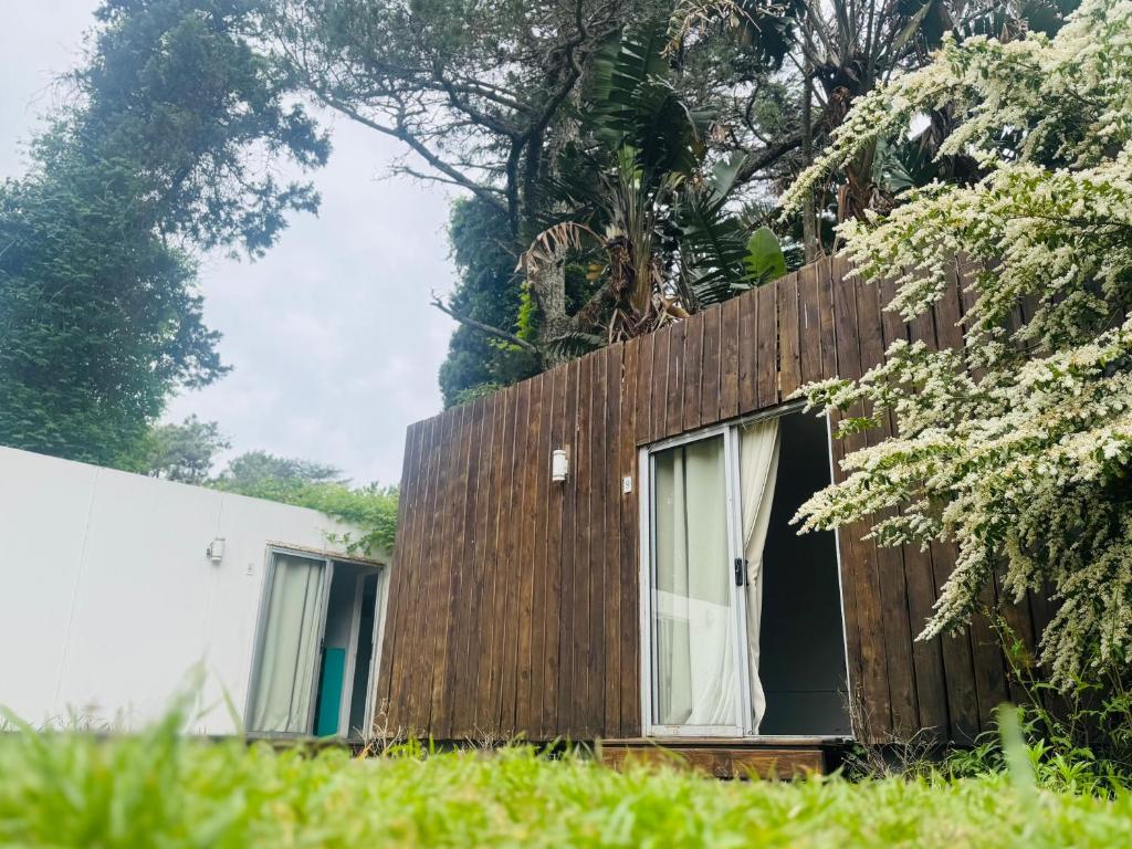 een huis met een houten muur en een raam bij Posada Punta del Este in Punta del Este