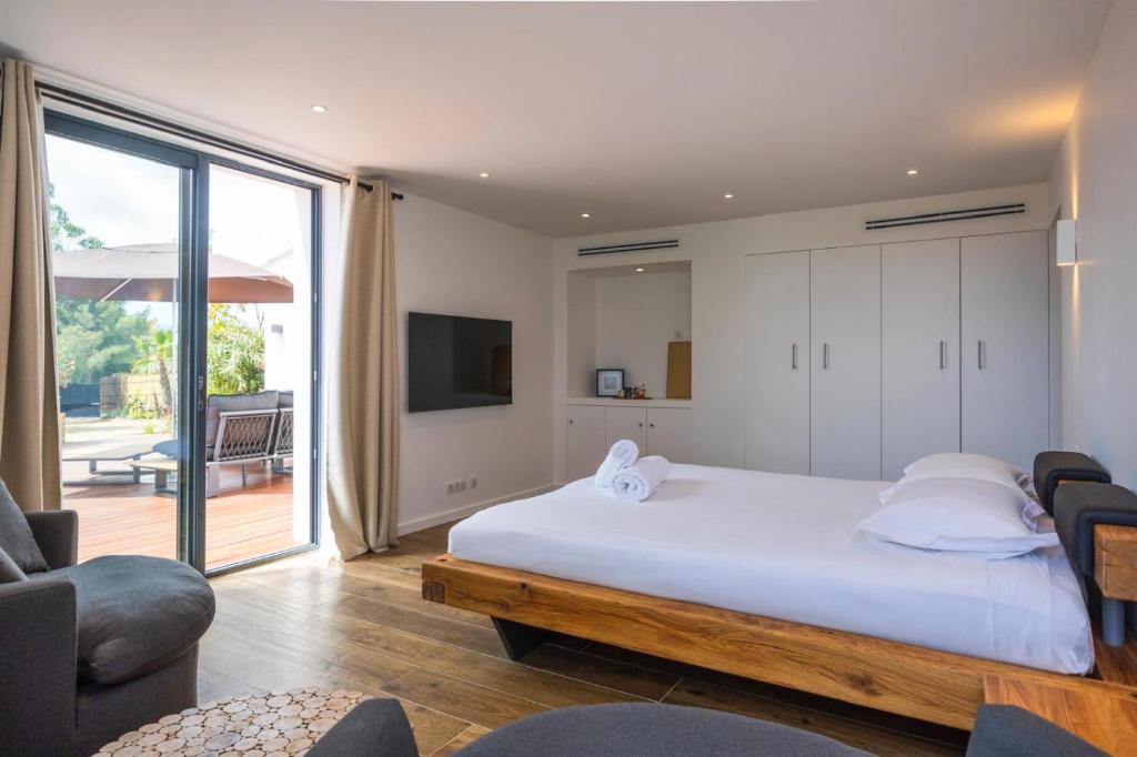 a bedroom with a large white bed and a television at Suite Île du Levant - Jardin & Piscine - 4 pers in La Croix-Valmer