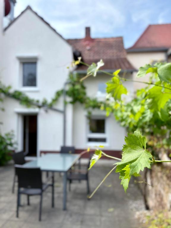 a table and chairs in front of a white house at Ferienhaus Lisbeth in Edesheim