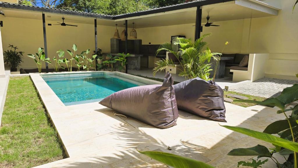 a swimming pool with two pillows in a yard at HomeVillas in Kuta Lombok