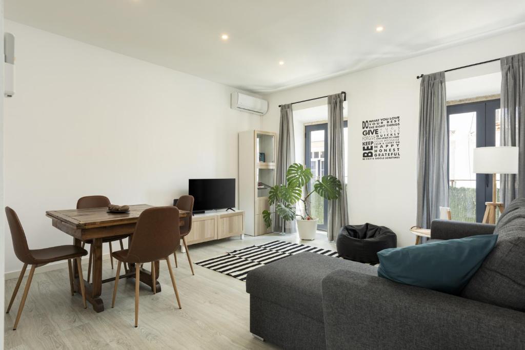 un salon avec une table et un canapé dans l'établissement Marggisa - City Center by HD, à Faro