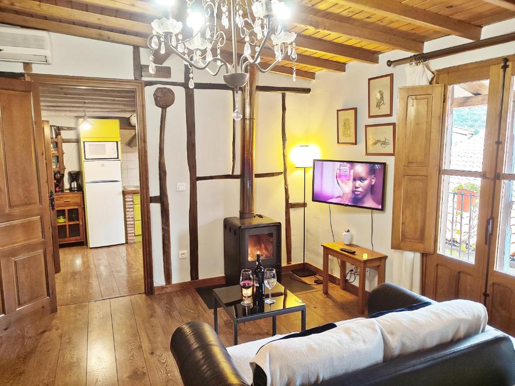 a living room with a couch and a fireplace at Alojamientos La Herrera in San Esteban de la Sierra