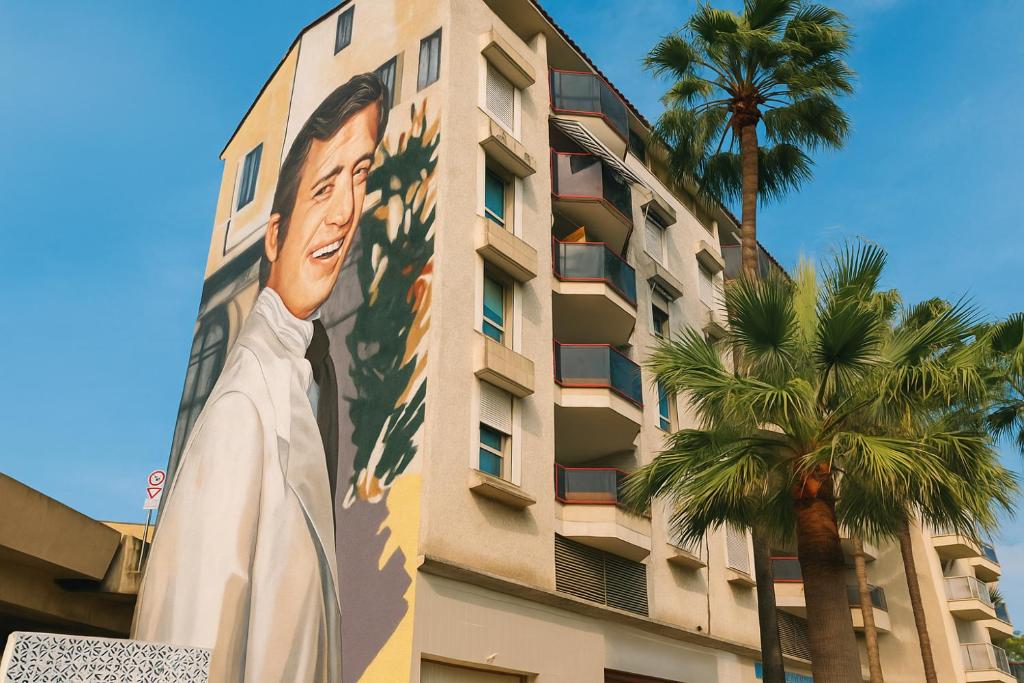 een muurschildering aan de zijkant van een gebouw met een palmboom bij Étoile Riviera - Studio 2P, Centre, Plages & Palais in Cannes