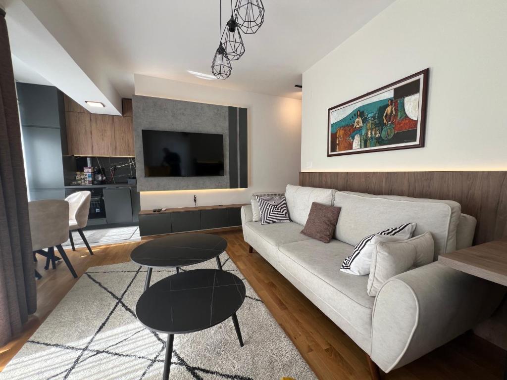 a living room with a couch and a table at UrbanNest Aerodrom in Skopje