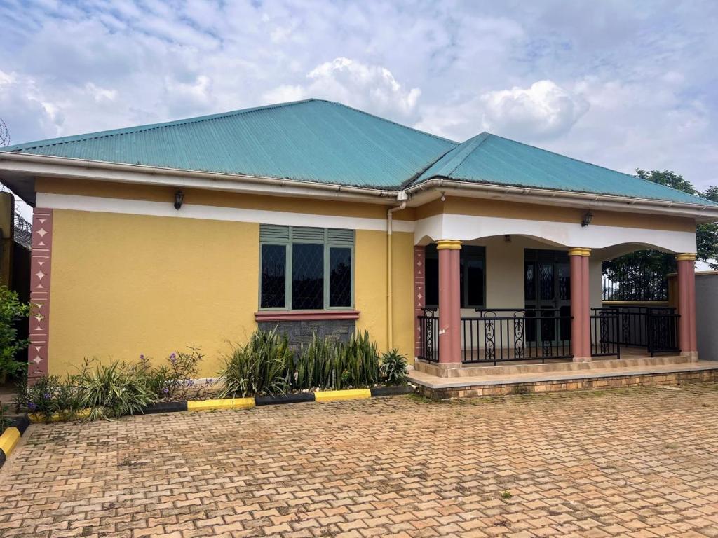 a yellow house with a green roof at Antique Family Residence in Kitala