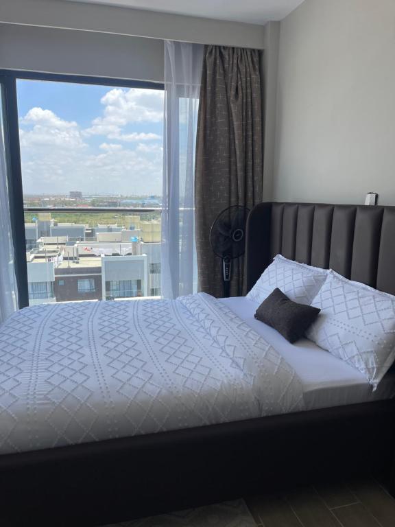 a bedroom with a bed and a large window at Hideaway holiday in Nairobi