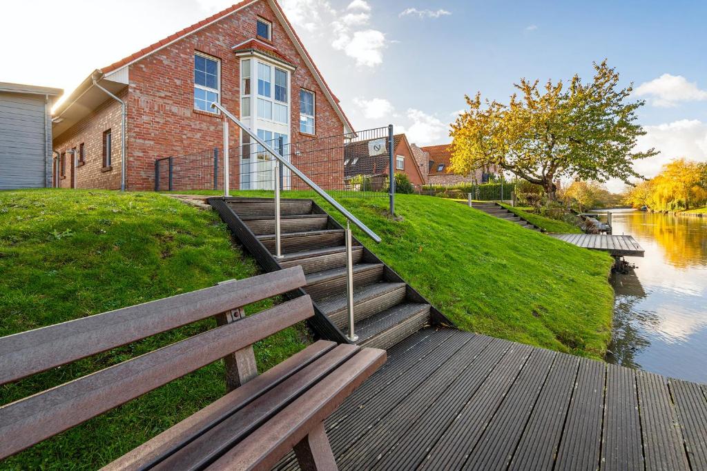 a group of stairs leading to a building next to a river at Kommewieder in Greetsiel