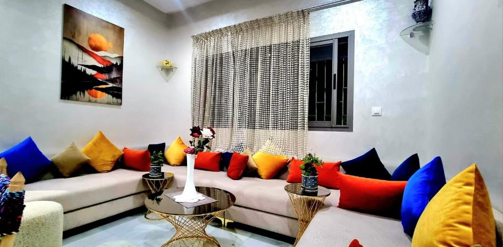 a living room with a couch with colorful pillows at Appart Ennakhil 4 avenue mohamed 6 in El Jadida