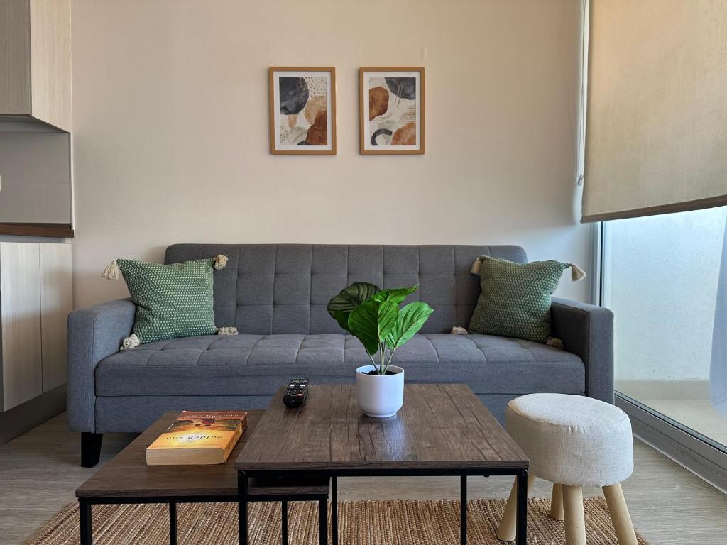 a living room with a blue couch and a table at Departamento nuevo a 5 min de la playa 2D 2B in La Serena
