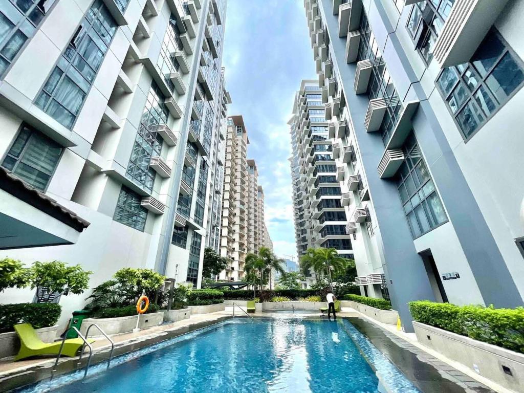 une piscine au milieu de deux grands bâtiments dans l'établissement The Viceroy Tower Staycation at McKinley Hills Taguig, à Manille