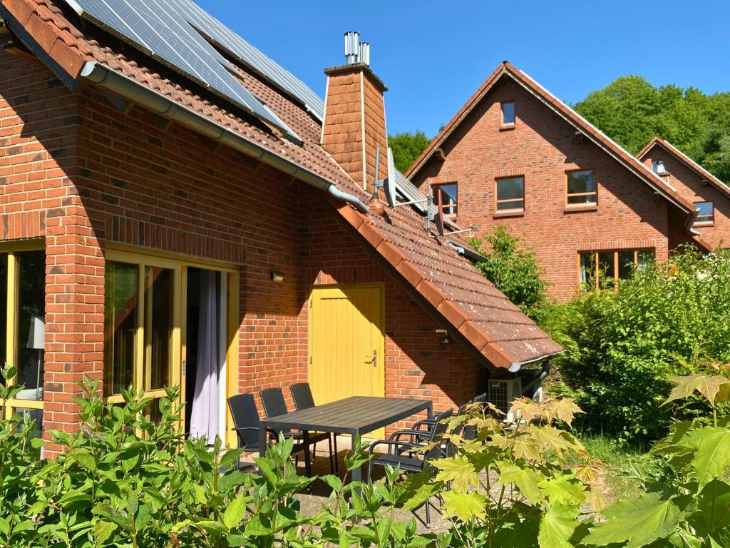 ein Backsteinhaus mit einem Tisch und einer gelben Tür in der Unterkunft Natur Ferienpark 26 - Typ A in Nieheim