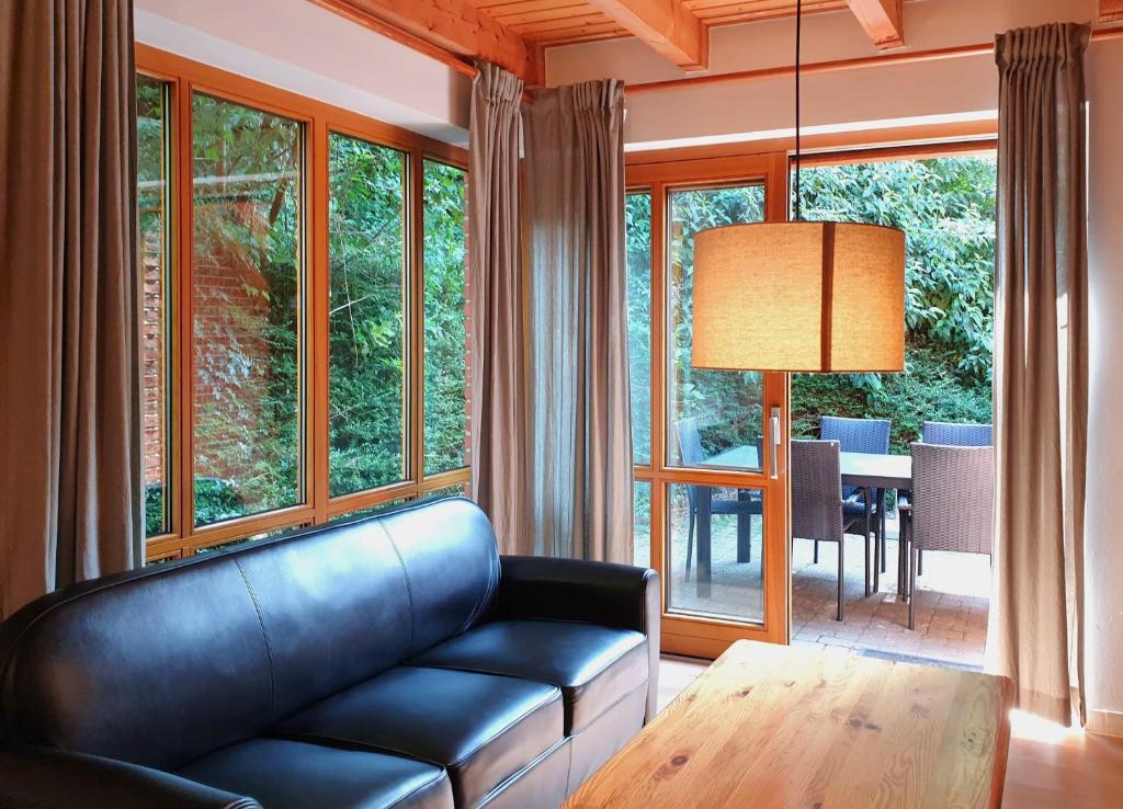 a living room with a leather couch and a table at Natur Ferienpark 8 - Typ A in Nieheim
