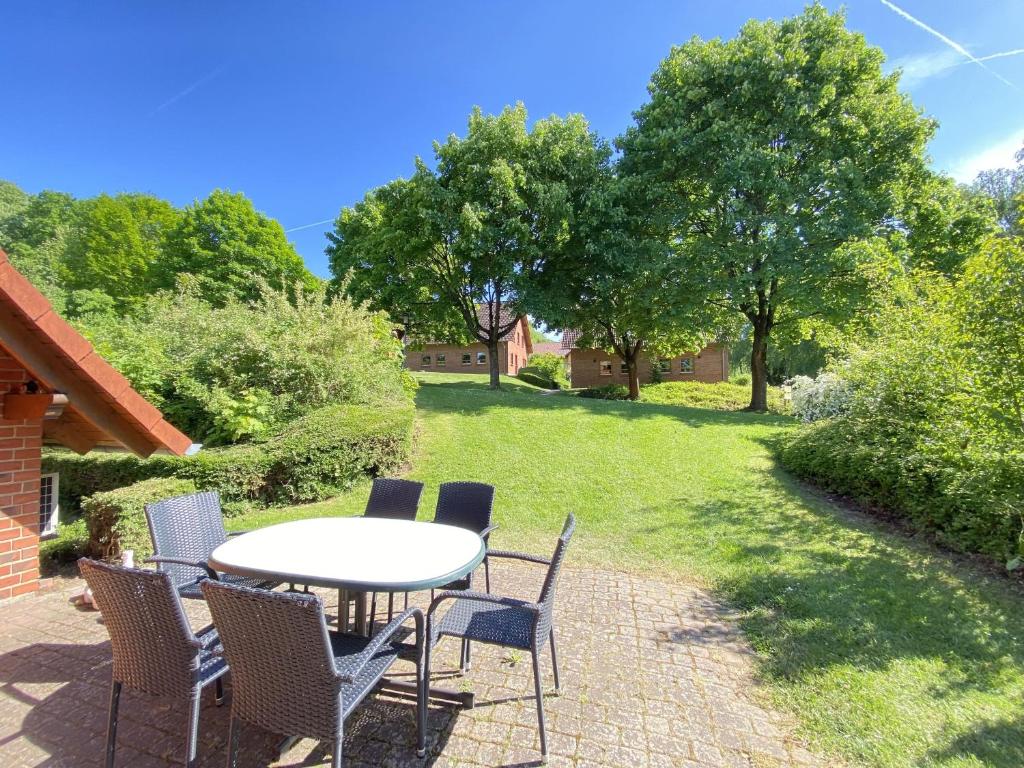 une terrasse avec une table et des chaises sur une pelouse dans l'établissement Natur Ferienpark 28 - Ferienhaus Typ A, à Nieheim