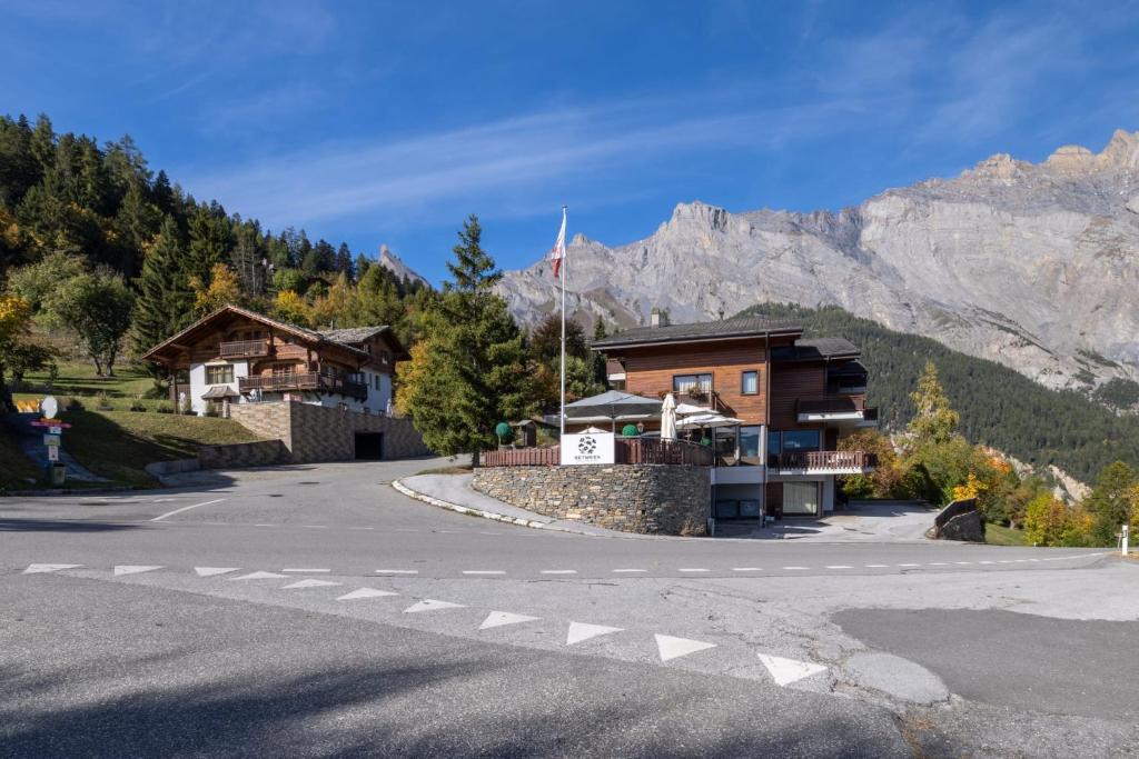 a building on the side of a road with a mountain at Between Boutique Hotel in Chamoson