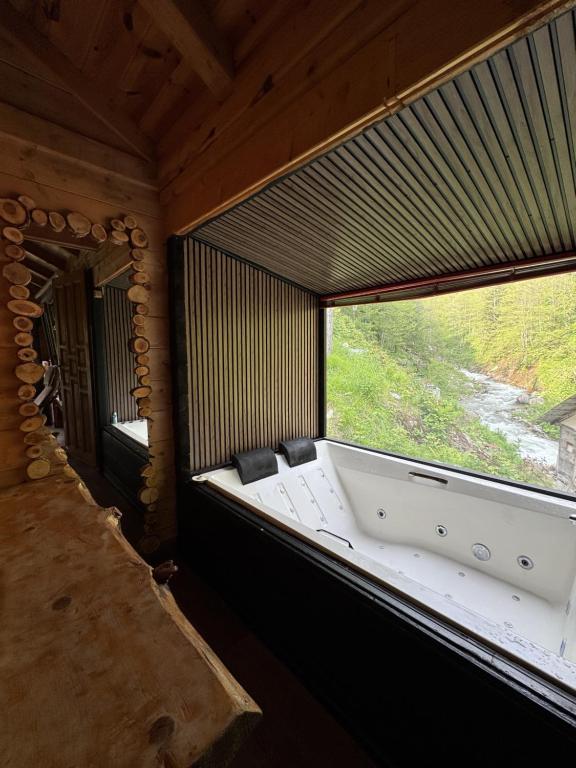 ein großes Fenster in einem Zimmer mit Badewanne in der Unterkunft Ayder Elizan Dağ Evleri in Çamlıhemşin
