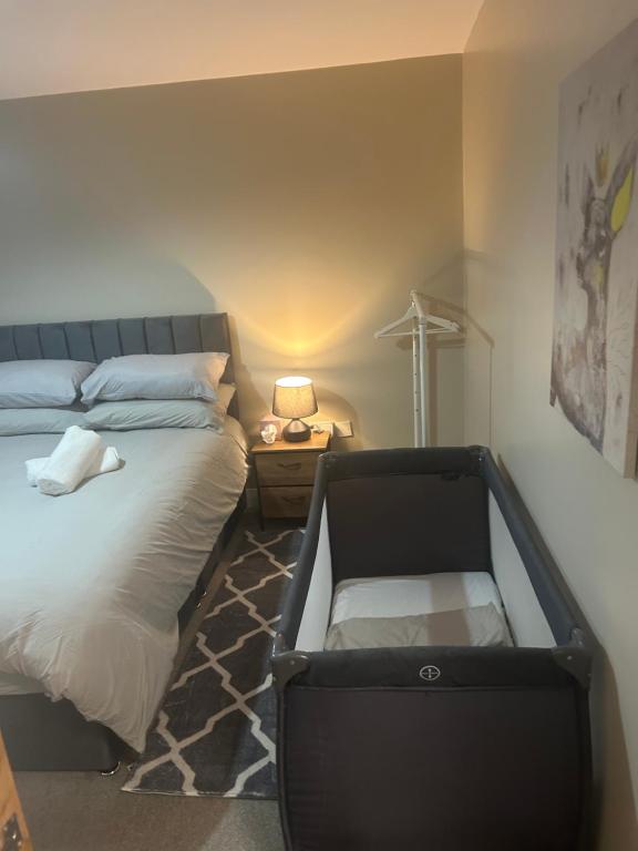 une chambre avec un lit avec un coffre sur le sol dans l'établissement New 4 stars Large prime city center 2 bed 2 bath duplex apartment with free secure parking, à Belfast