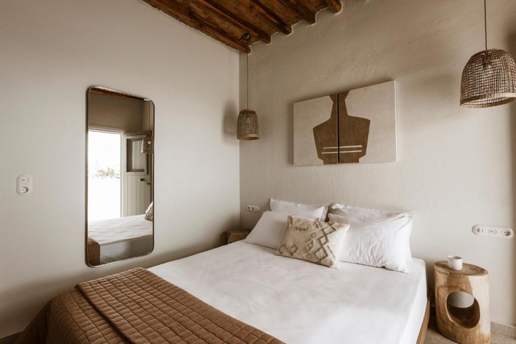 a bedroom with a large white bed with a mirror at Kisari Kimolos Chorio Double Room in Kimolos