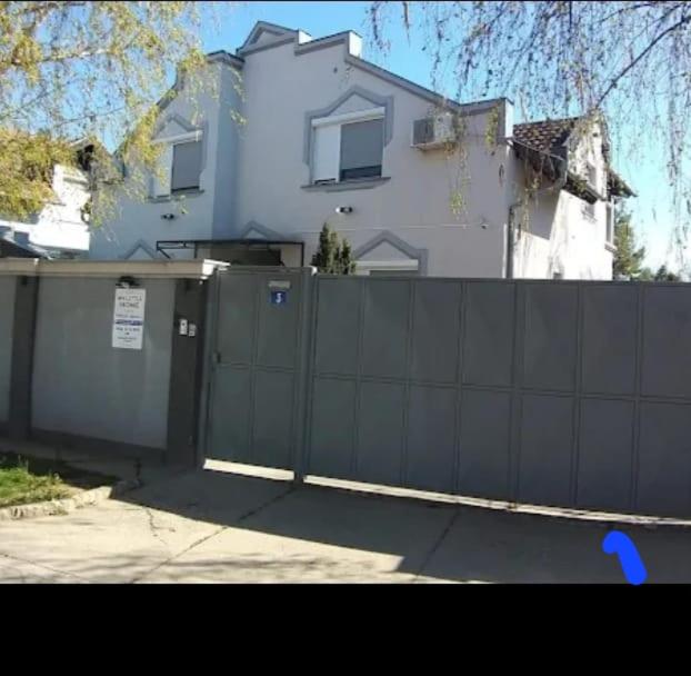 a black fence in front of a white house at Prenociste Aurelia in Subotica
