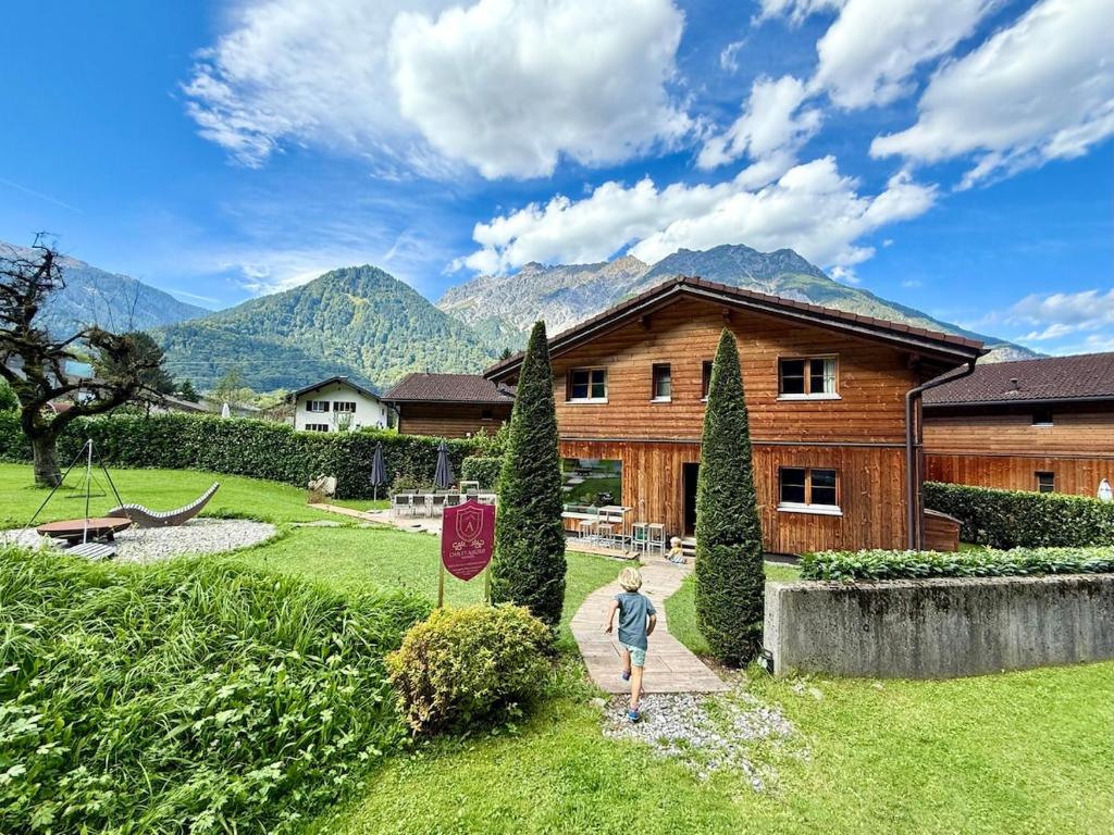 a person standing in a yard in front of a house at Chalet Auszeit Montafon in Bartholomäberg