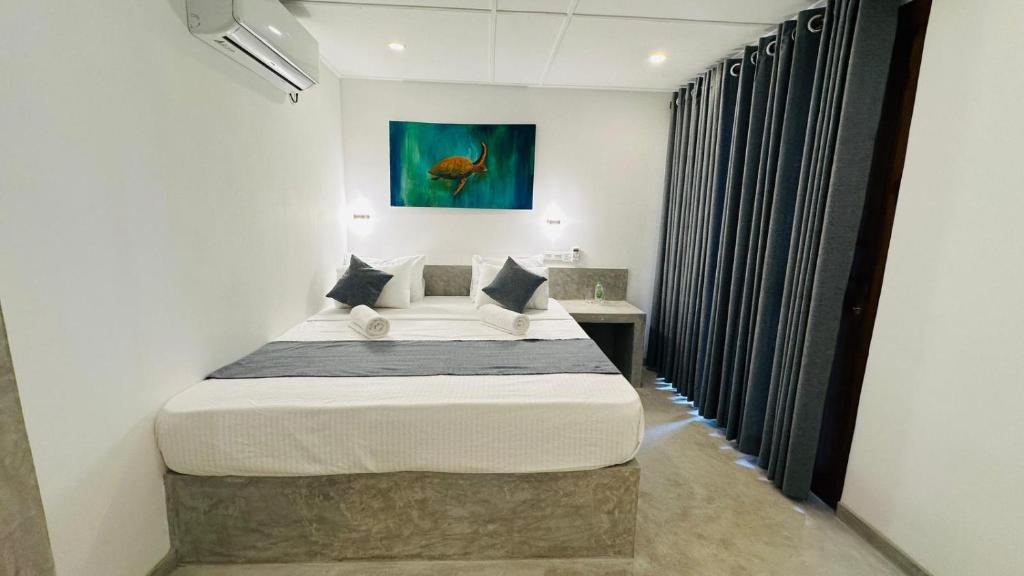 a bedroom with a bed and a painting on the wall at Royal Sea Wind in Matara