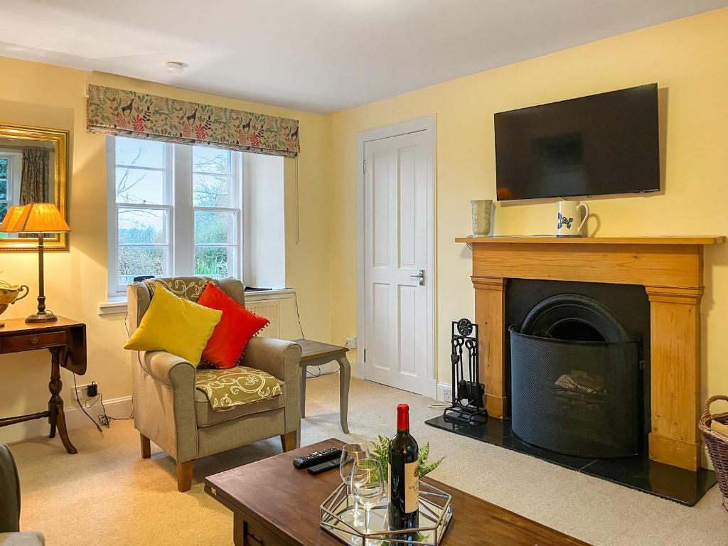 een woonkamer met open haard en tv bij Baldowrie Lodge in Ardler