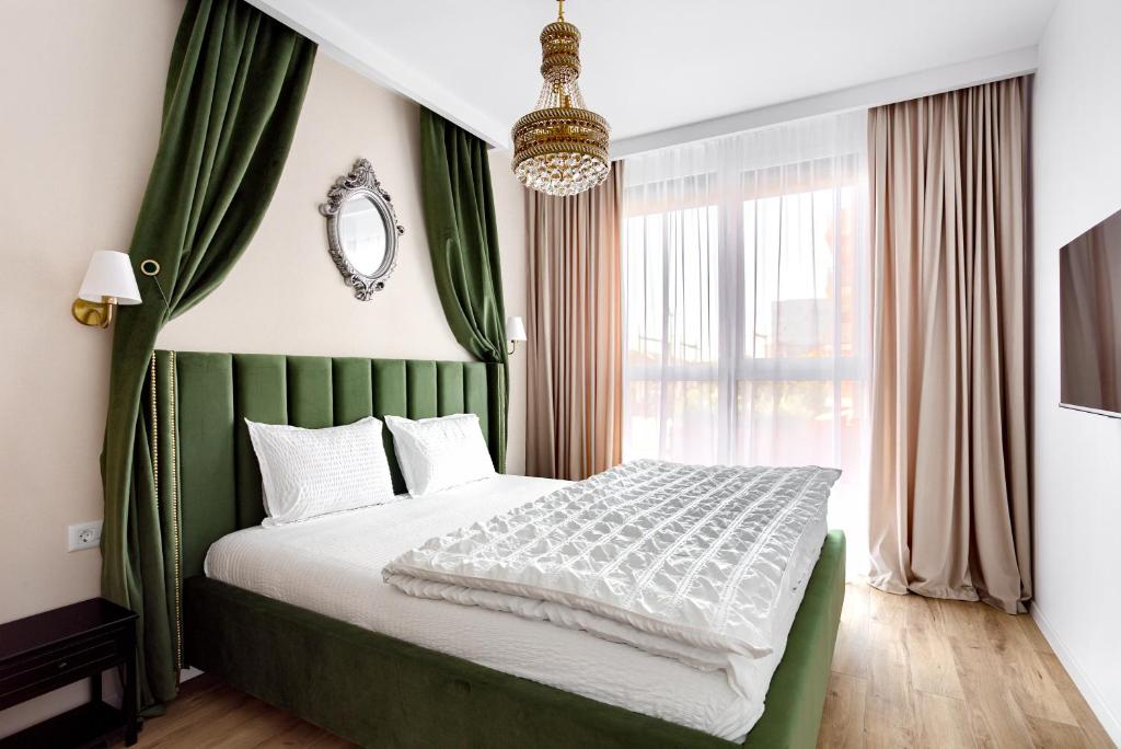 Schlafzimmer mit einem Bett mit einem grünen Kopfteil und einem Fenster in der Unterkunft Sika Opulent Grand Apartment in Arad