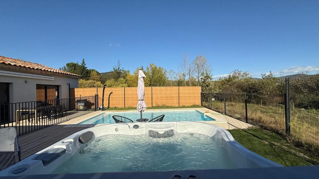 a pool with a hot tub in a backyard at Maison neuve Jacuzzi et Piscine Haut de Gamme in Vallon-Pont-dʼArc