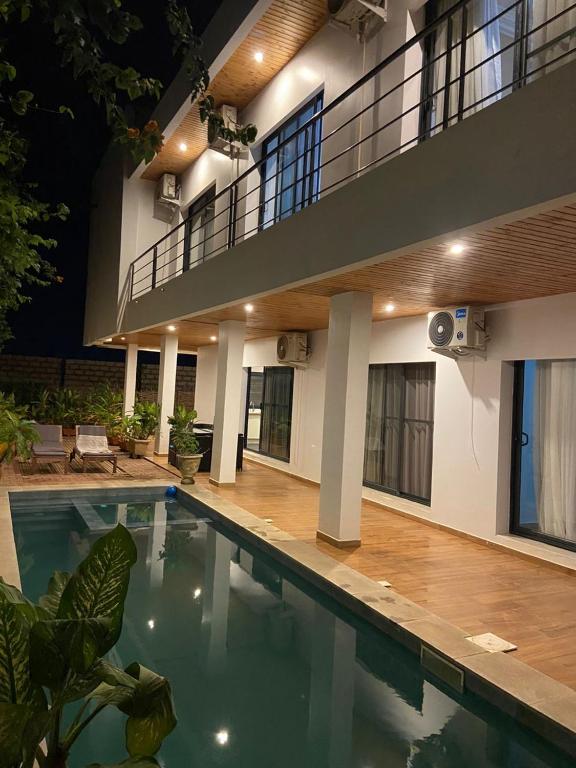 a house with a swimming pool in front of a building at Villa Le Charme de Somone Piscine privée confort & proximité plage in Somone