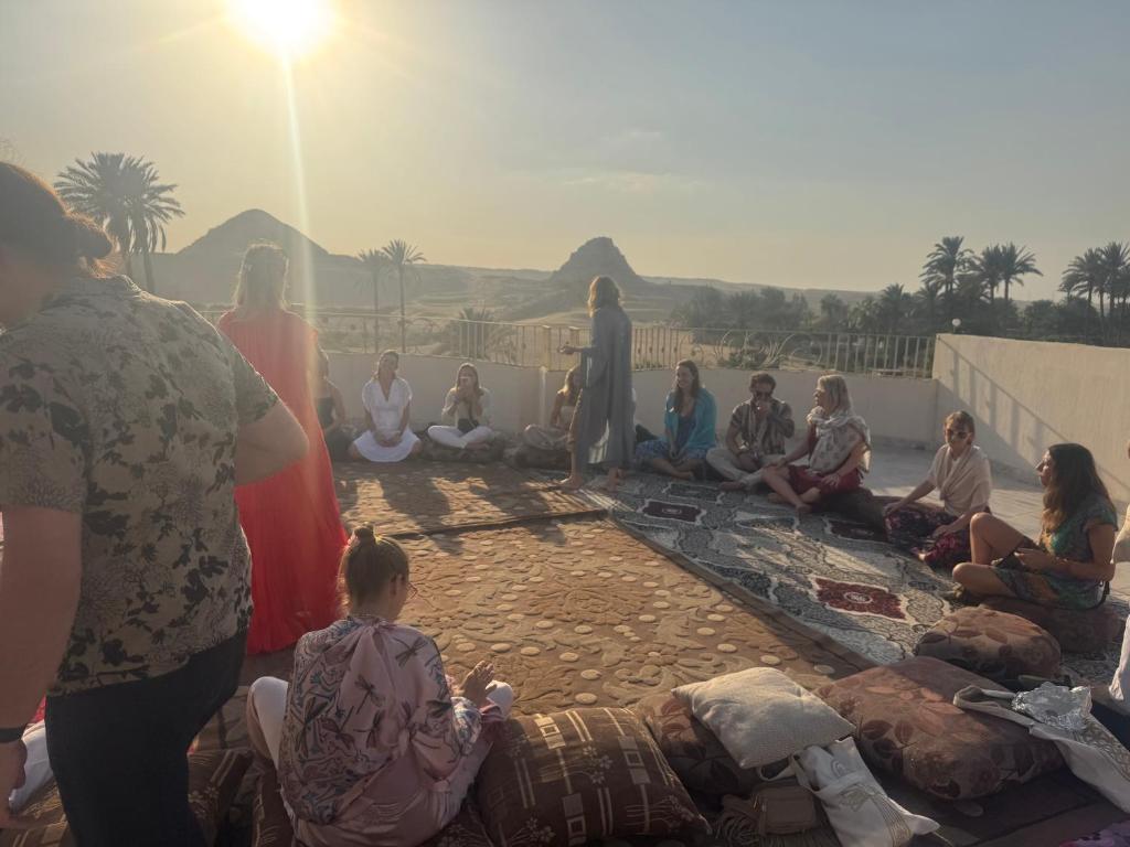 a group of people are sitting on the ground at Sun Temple Palace in Cairo