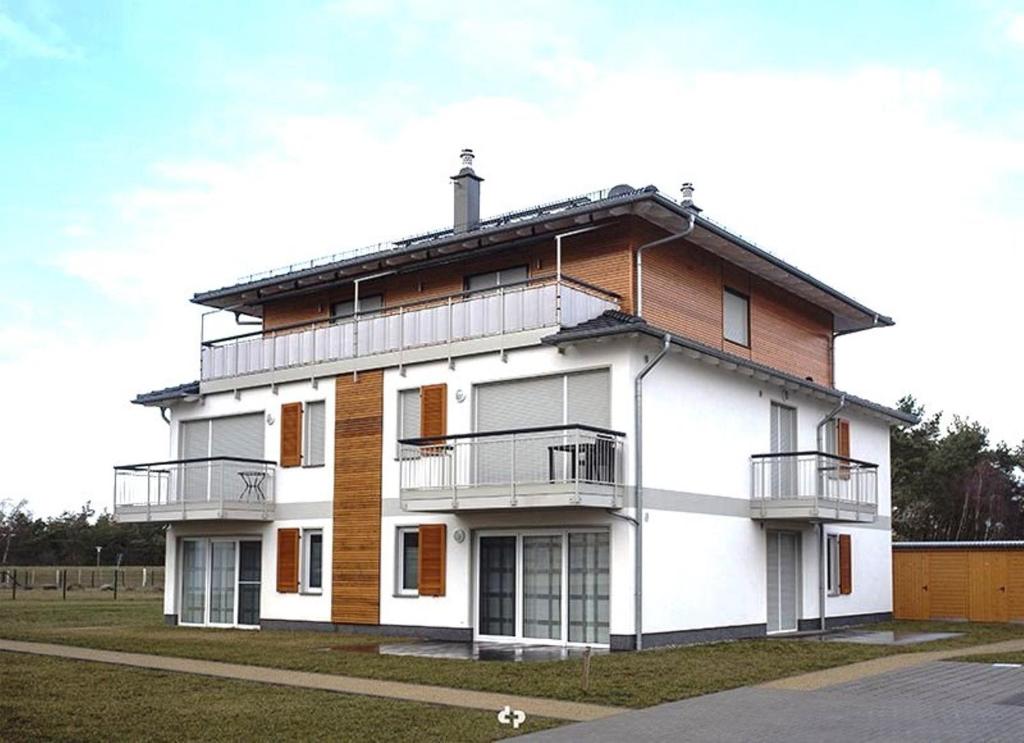 a large white building with balconies on a street at WINDLICHT App Nr 3 max 4 Pers in Dierhagen