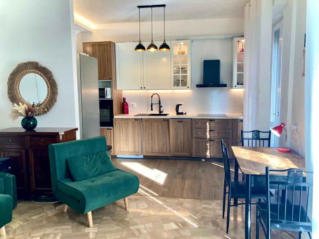 a kitchen with a table and a green chair at Charming king studio with balcony and jacuzzi in Como