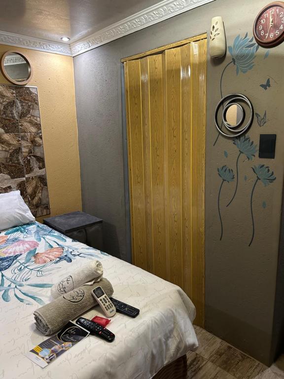 een slaapkamer met een bed met afstandsbediening bij Lake boutique hotel empire in Thohoyandou