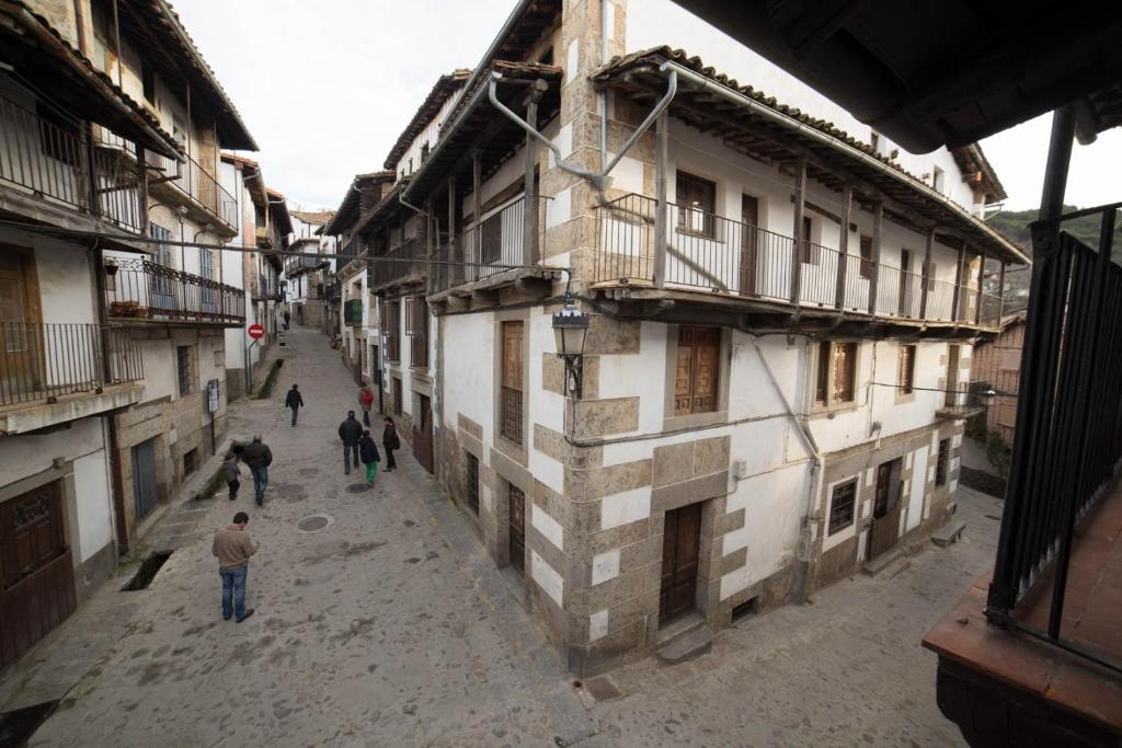 een groep mensen die in een straat naast gebouwen lopen bij Casa Rural LA REGADERA I in Candelario