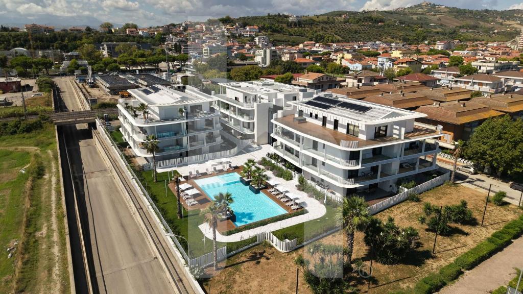 an aerial view of a large white building with a swimming pool at Homiday - WaterFront Roseto in Roseto degli Abruzzi