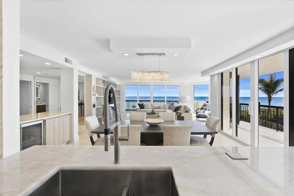 a kitchen and living room with a view of the ocean at Elegant Three-Bedroom Oceanfront Apartment with Designer Finishes in South Palm Beach