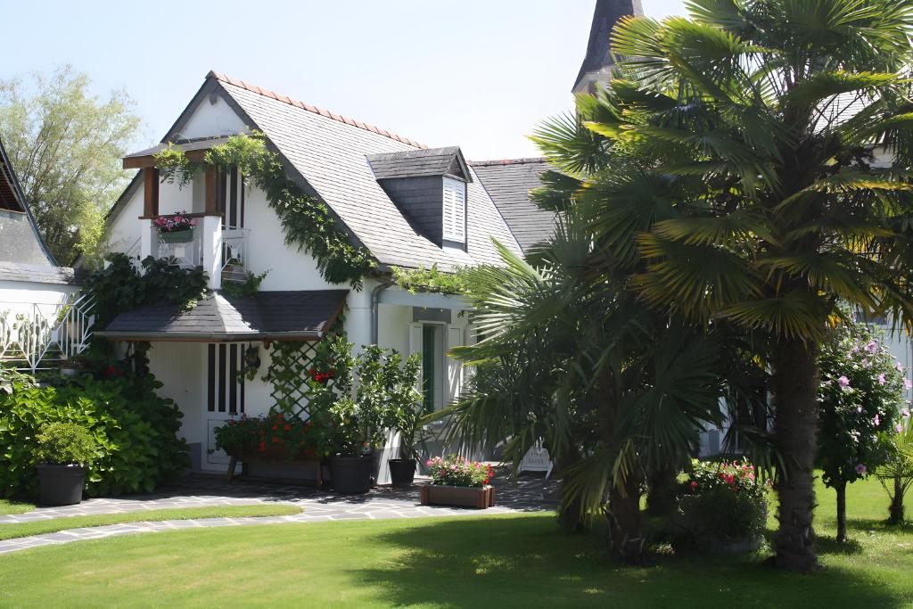 een wit huis met een palmboom in de tuin bij Gite Chez Balum - 1 proche Lourdes in Lézignan