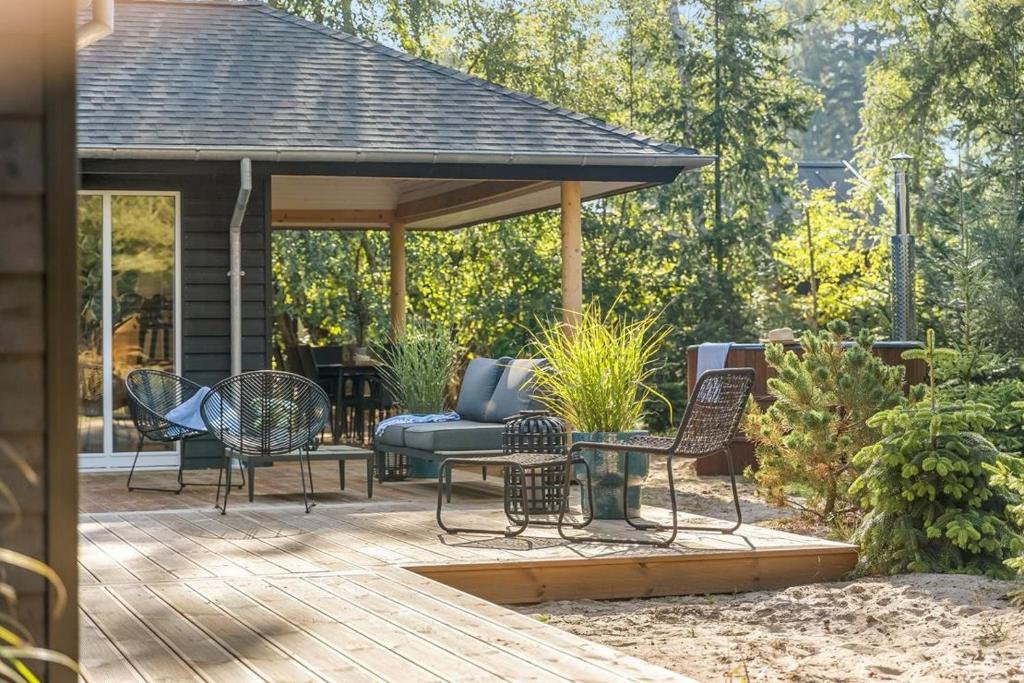 a patio with a gazebo with chairs and a table at Architect-Designed Holiday Home Close To The Water in Marielyst