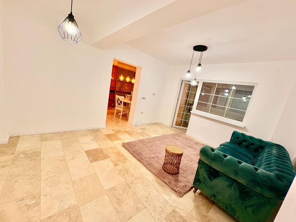 a living room with a green couch and a table at Ultracentral 1 Craiova in Craiova