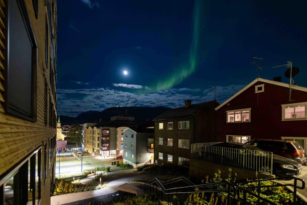 an aurora in the sky over a city at night at Modern Apartment in Tromsø Center in Tromsø