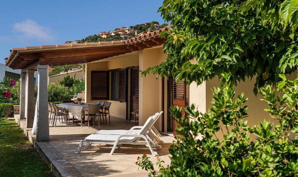 een patio met een tafel en stoelen op een huis bij Villa Rosamar in Monte Nai