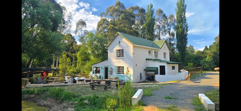 a white house with a picnic table in front of it at Bunkers Accomodation in Underberg