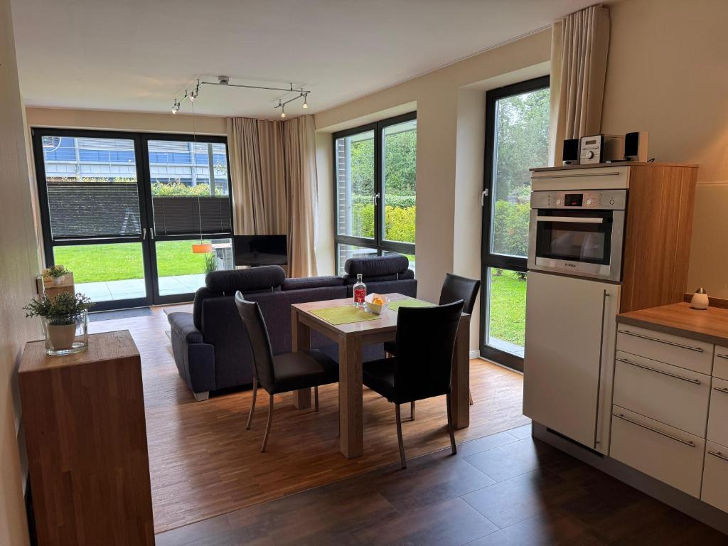 a kitchen and living room with a table and a couch at Moderne Ferienwohnung 2 Pers in Bad Zwischenahn