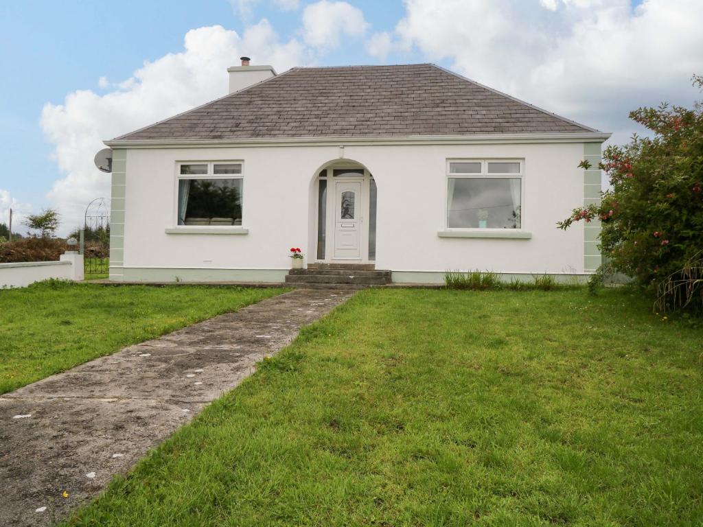 a white house with a lawn in front of it at Carrowreagh in Aclare